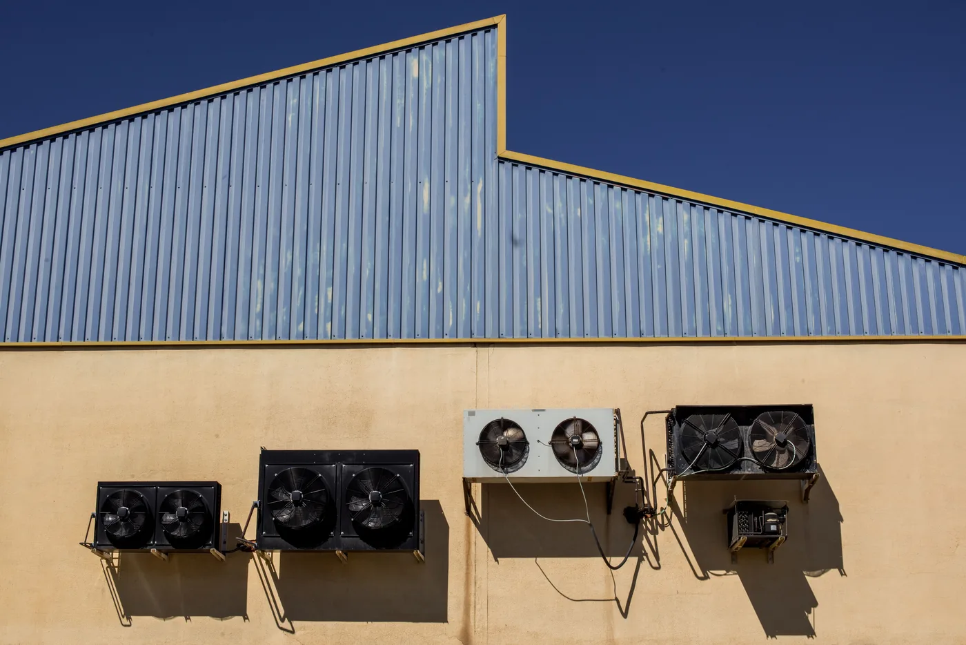 Industrial cooling and ventilation units mounted on a warehouse wall
